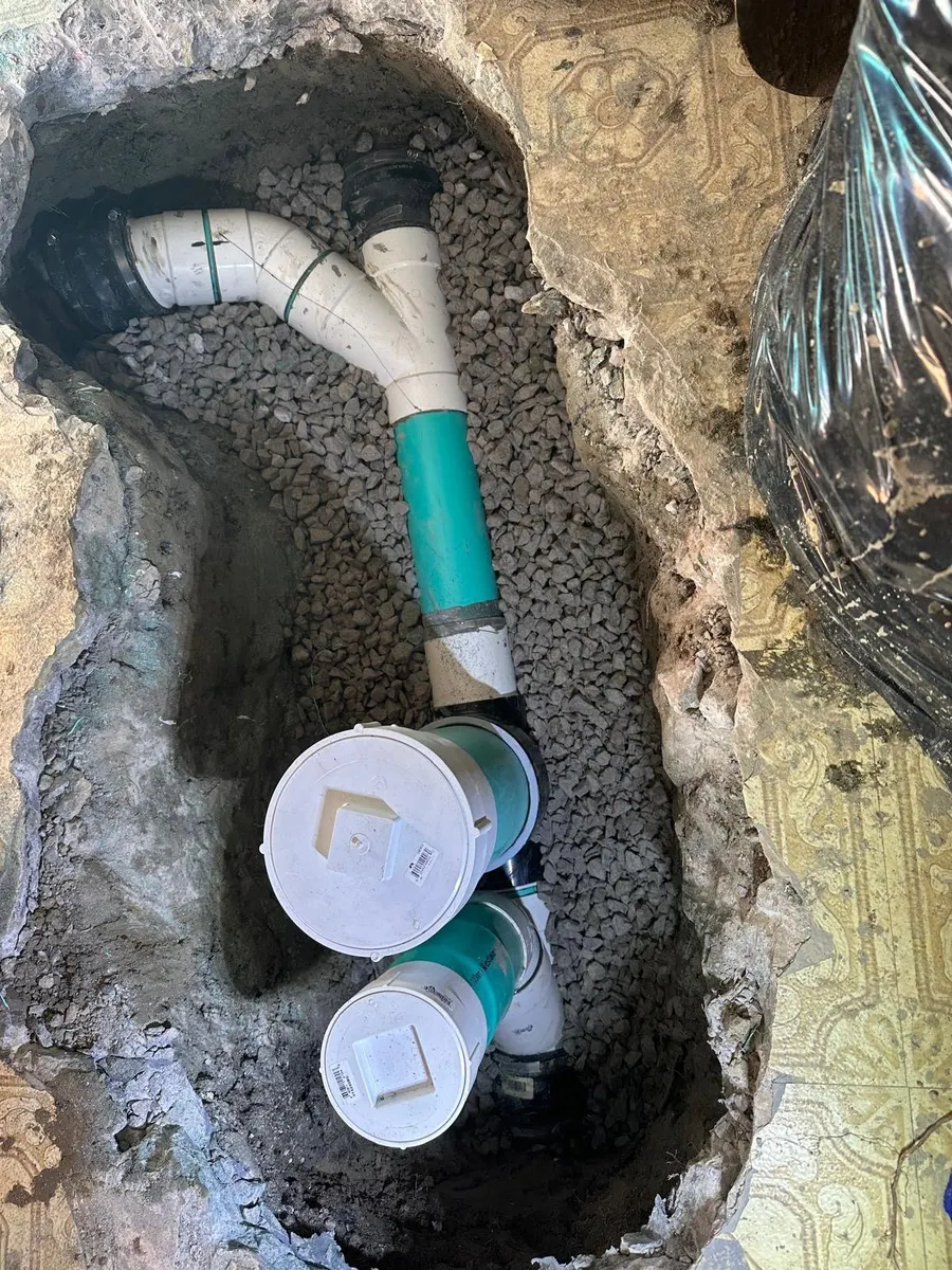 New PVC drain piping and cleanouts in an opened basement floor