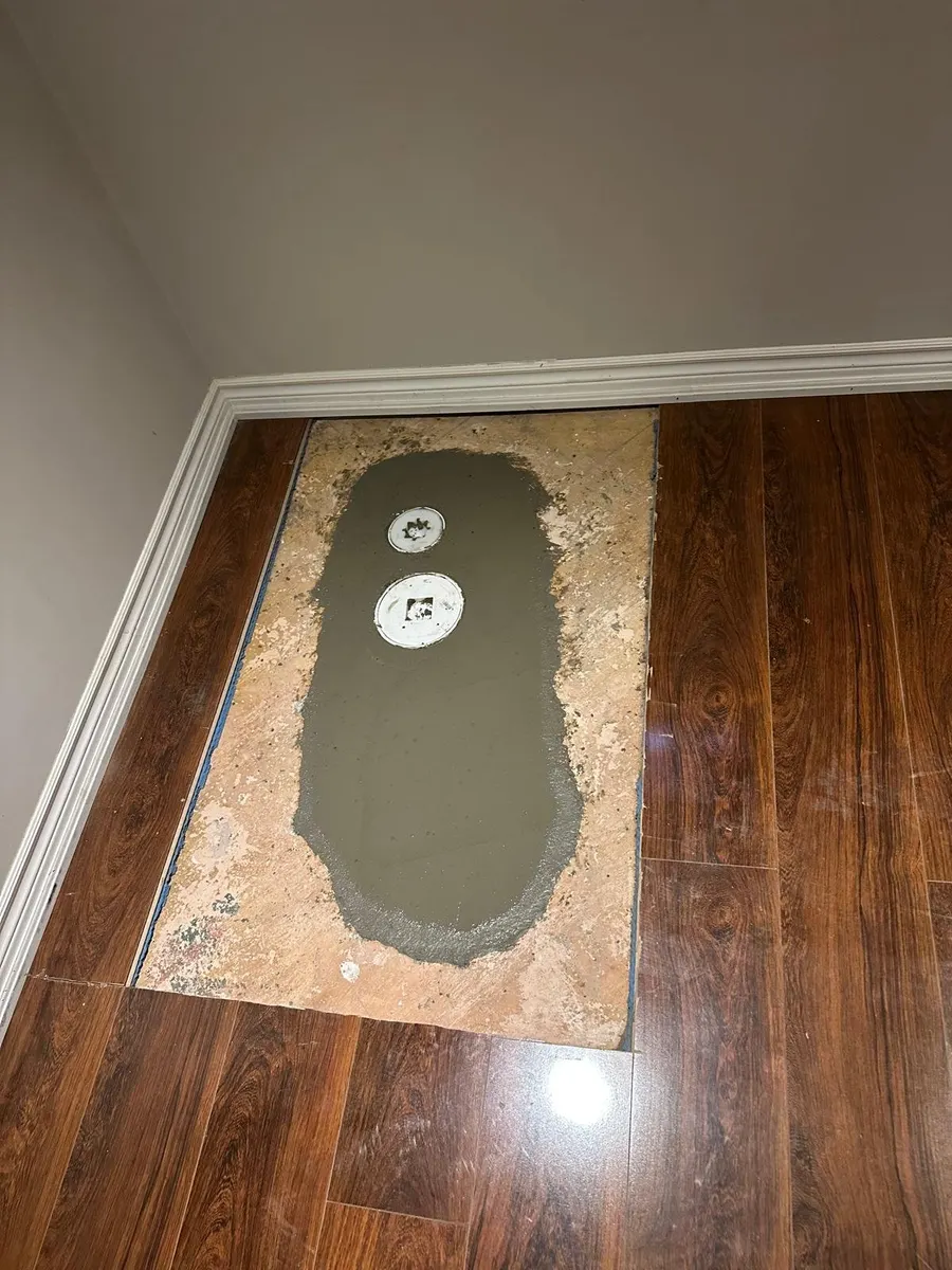 Concrete floor patched over new cleanouts after drain work