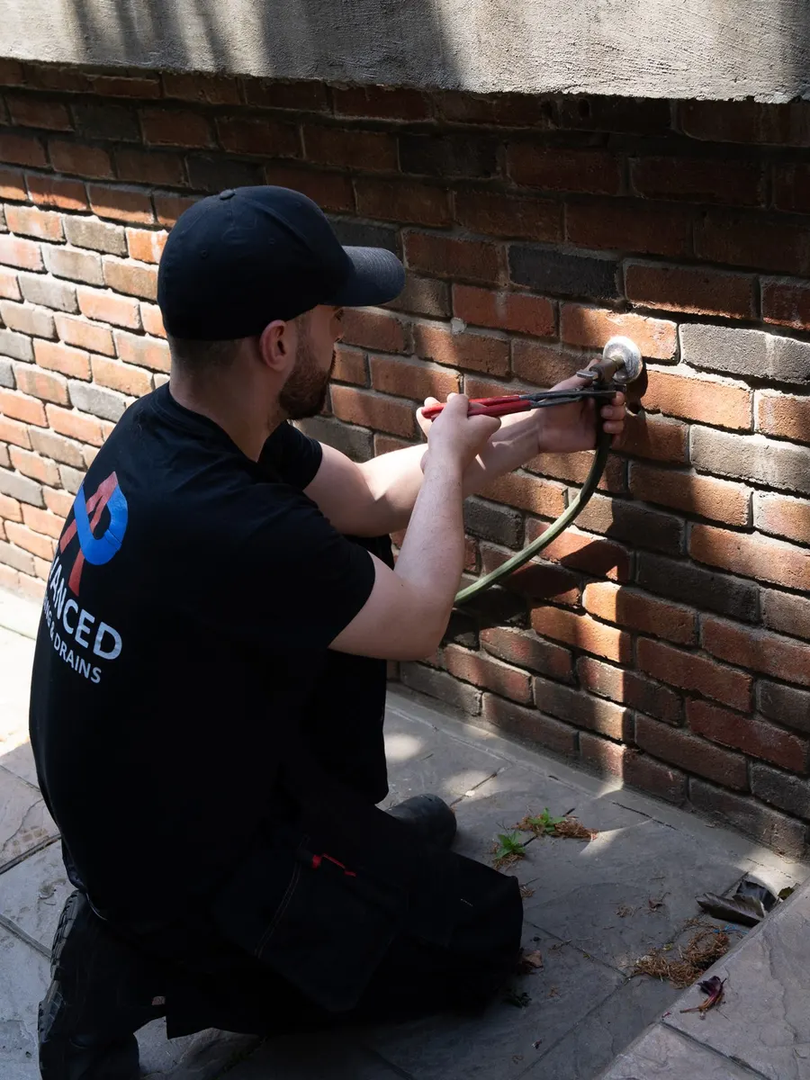Working on an outdoor hose bib
