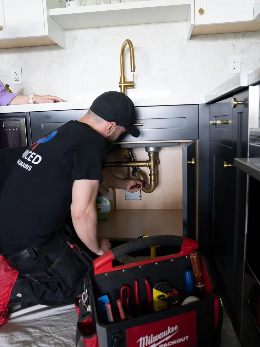 Working on a brass P-trap under a kitchen sink