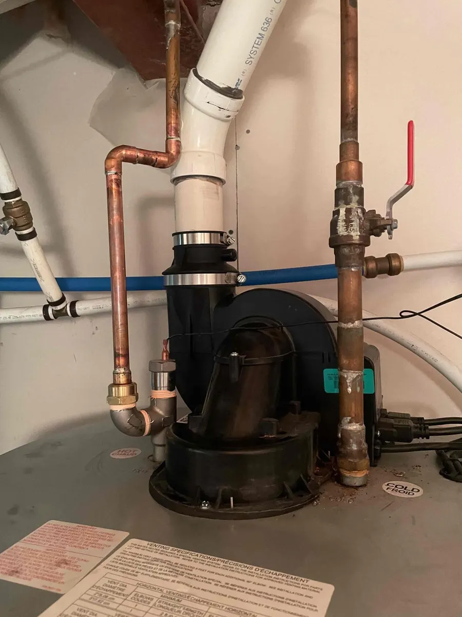 Power-vented water heater with copper and PVC venting